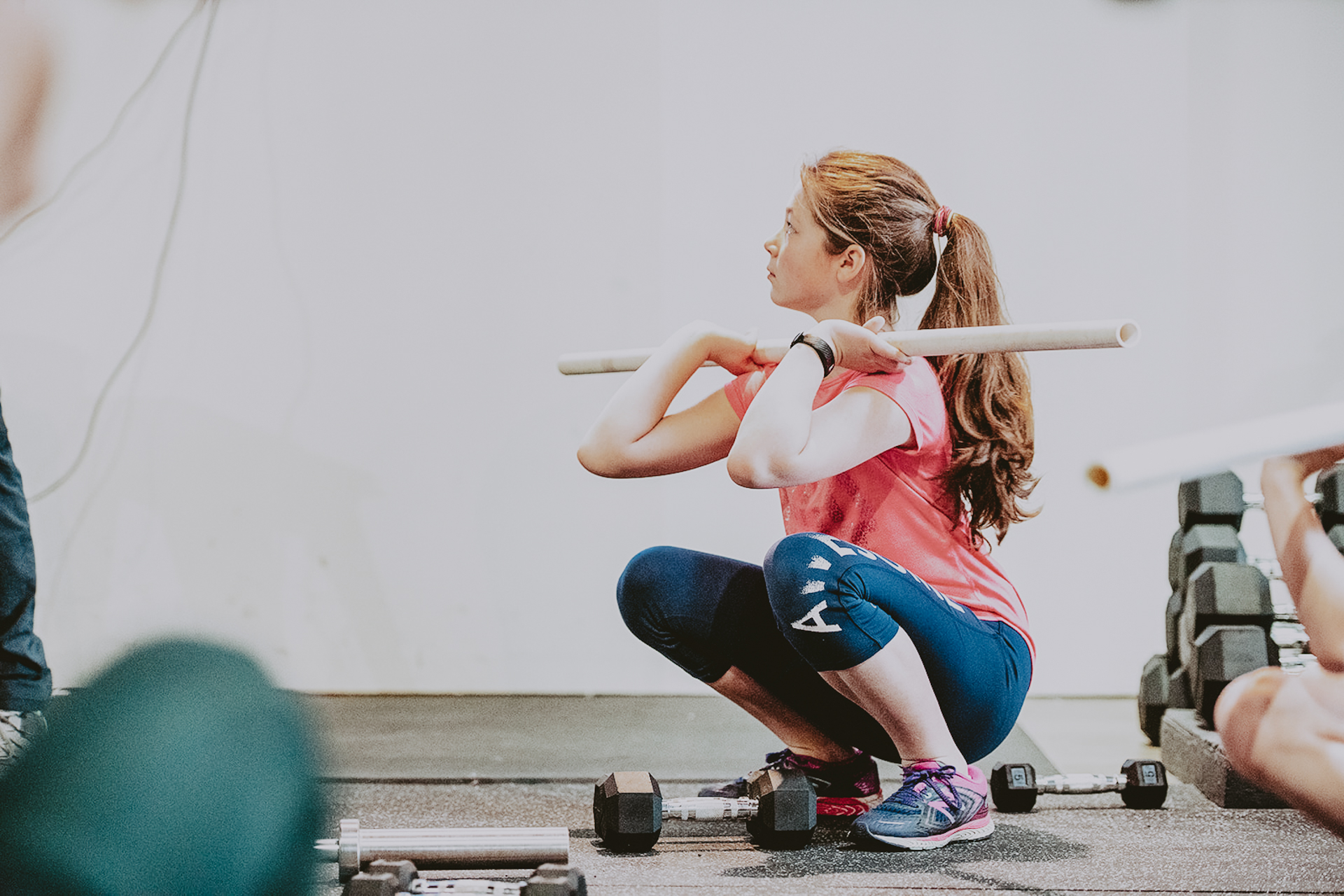 A-young-girl-does-a-crossfit-squat-with-pvc-pipe-in-victoria-bc-gym